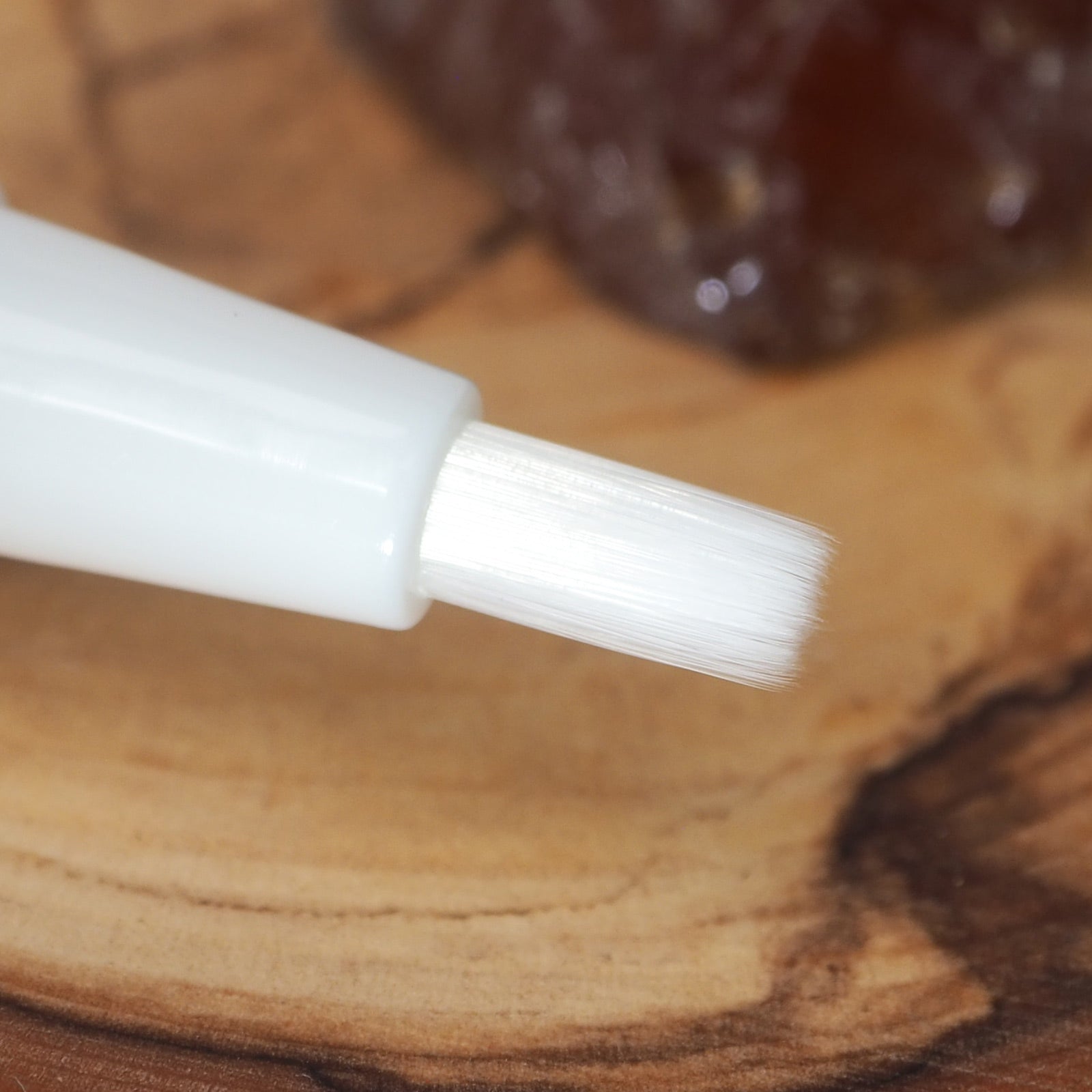 weißer Pinsel zum auftragen eines geöffneten Nagelhautpflegestiftes