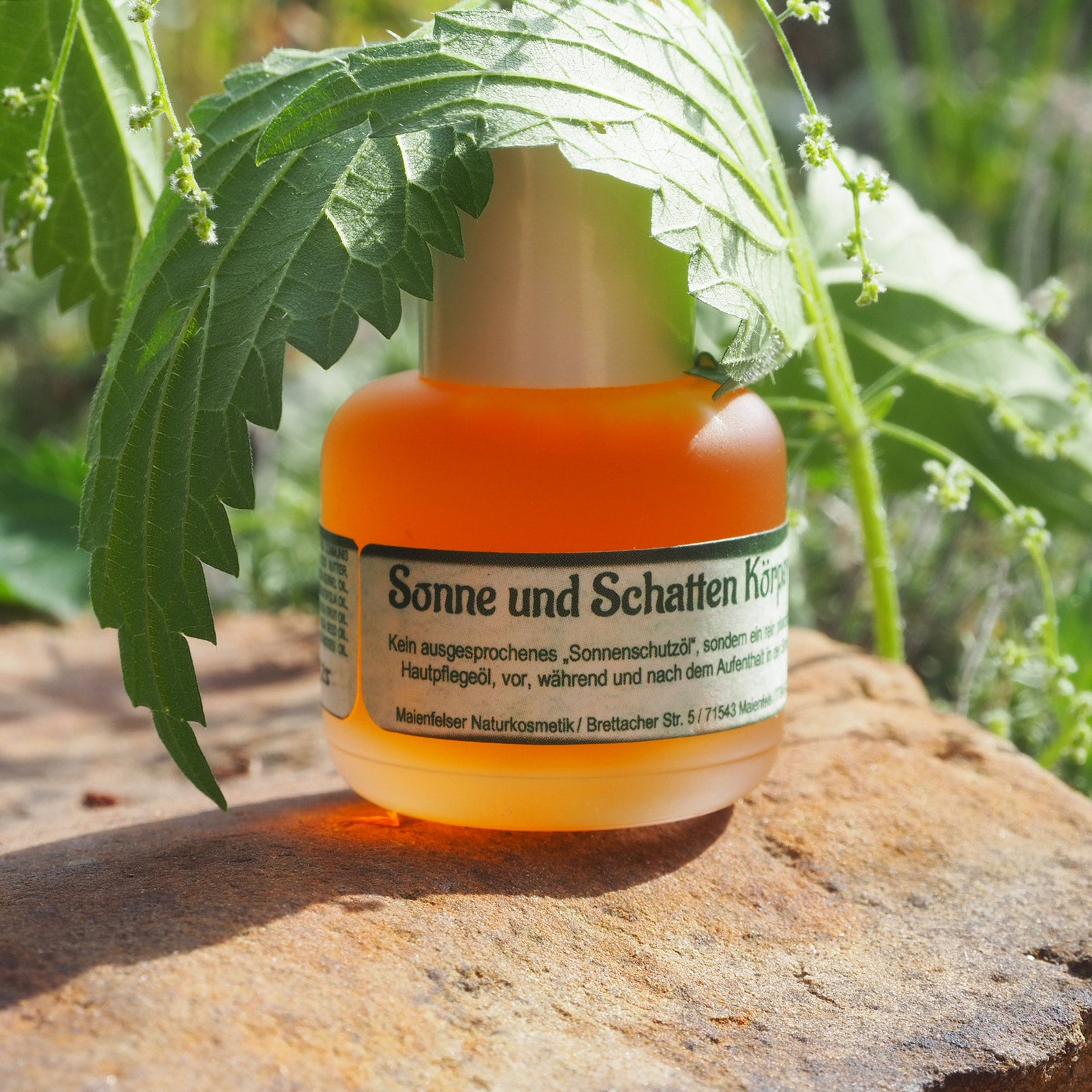 Sonne und Schatten Körperöl 15ml abgedeckt mit einem Brennnesselblatt
